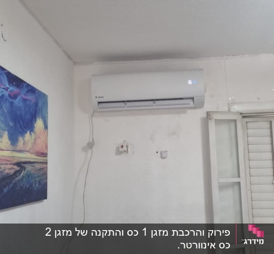 מזגן מותקן על קיר לבן עם שלט על הספה